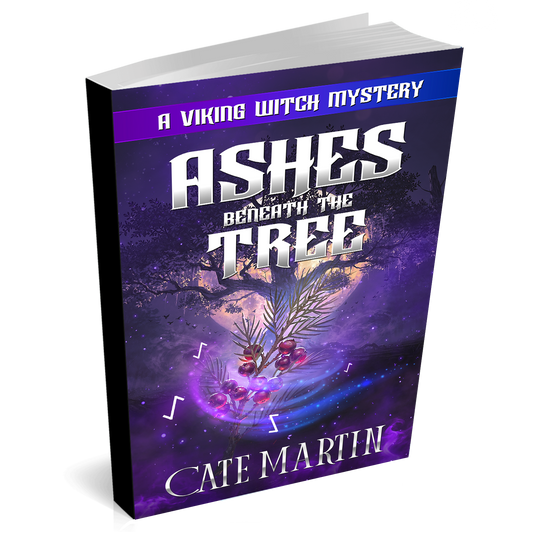 Image is of a paperback book titled Ashes Beneath the Tree: A Viking Witch Mystery. The image is of a tree with the moon rising behind it. There is a sprig of yew berries in the foreground with glowing runes spinning around it.